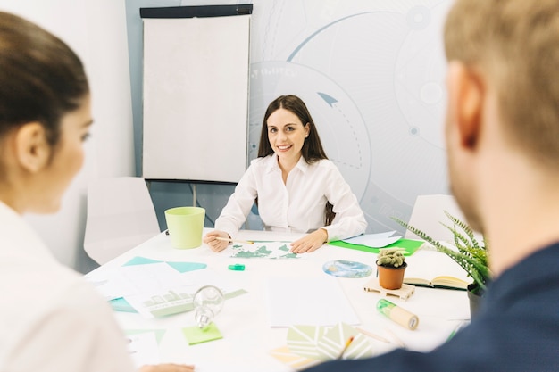 Feliz mujer gerente sentado en la oficina