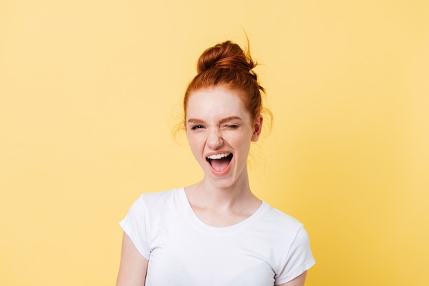 Feliz mujer de jengibre en camiseta guiños