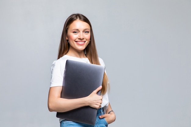 Feliz, mujer joven, tenencia, computador portatil, y, posar