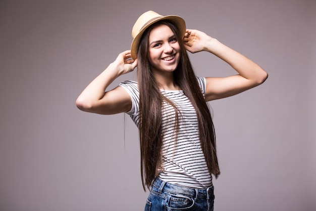 Foto gratuita feliz mujer juguetona vistiendo fedora de paja de verano mirando hacia el lado sobre el hombro