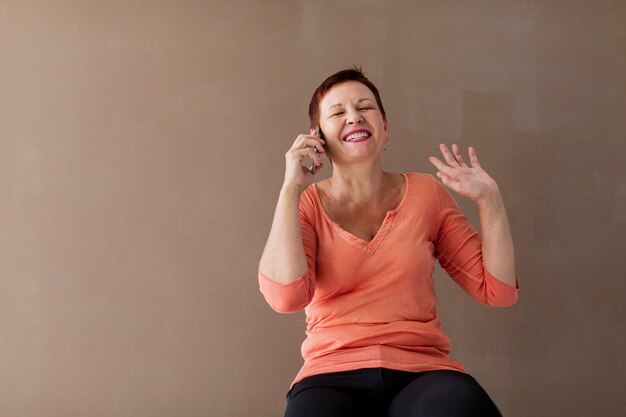 Feliz mujer madura riendo en el teléfono