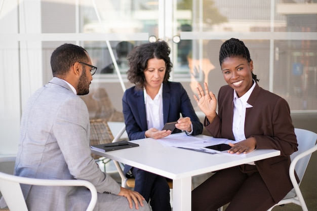 Foto gratuita feliz mujer de negocios afroamericano saludando hola