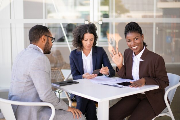 Feliz mujer de negocios afroamericano saludando Hola