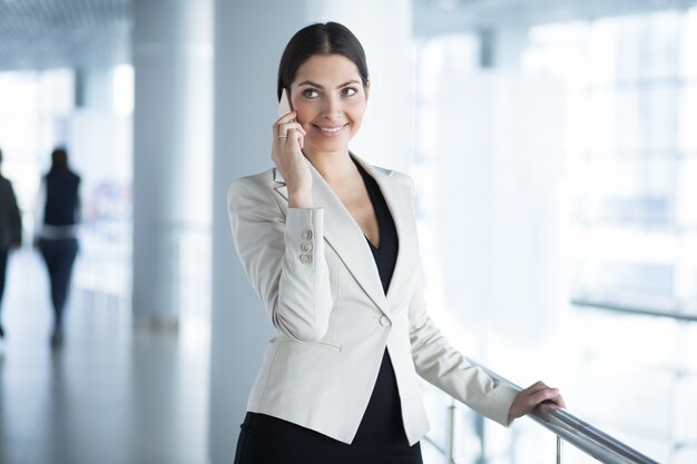 Feliz, mujer de negocios, llamada, teléfono, pasillo