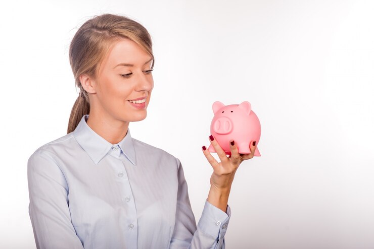 Feliz mujer de negocios con sus ahorros en una alcancía
