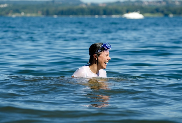 Feliz mujer con pelo corto en medio de las tranquilas aguas de un lago