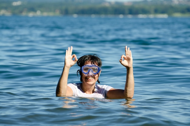 Foto gratuita feliz mujer con pelo corto en medio de las tranquilas aguas de un lago