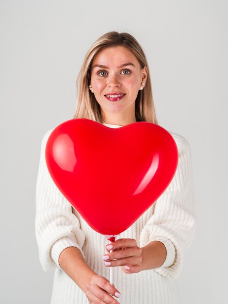 Feliz mujer posando con globo para San Valentín
