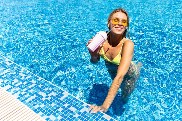 Feliz mujer posando en la piscina