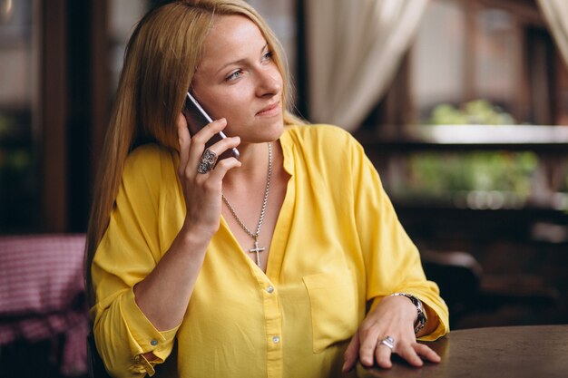 Feliz mujer rubia de pelo hablando por teléfono