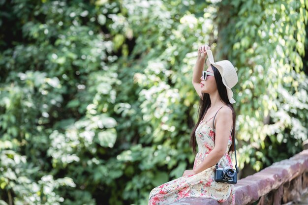 Feliz mujer sentada en la baranda en un parque