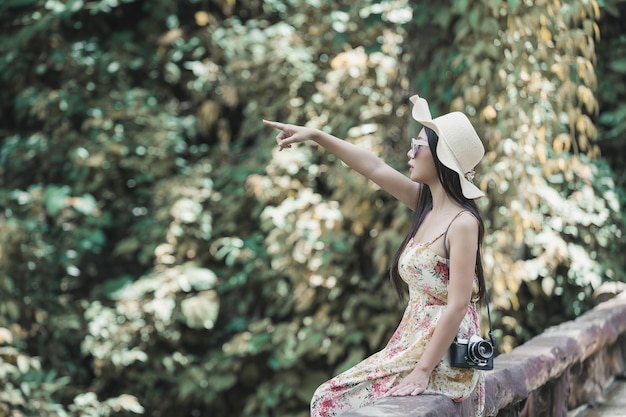 Foto gratuita feliz mujer sentada en la baranda en un parque