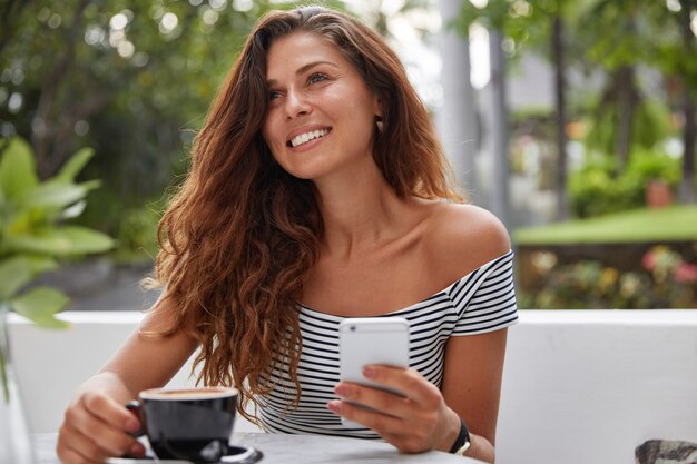 Feliz mujer sentada en una cafetería