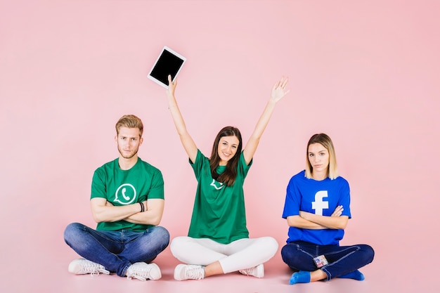 Foto gratuita feliz mujer sentada entre sus dos amigos tristes con los brazos levantados