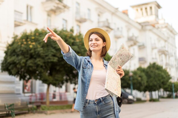 Feliz mujer con sombrero apuntando al paisaje