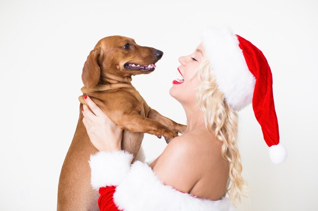 Feliz mujer con sombrero de Santa con perro amado