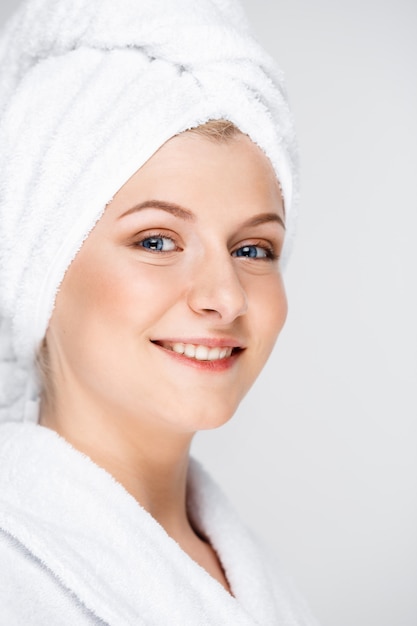 Feliz mujer sonriente aplicar crema facial, concepto de cuidado de la piel