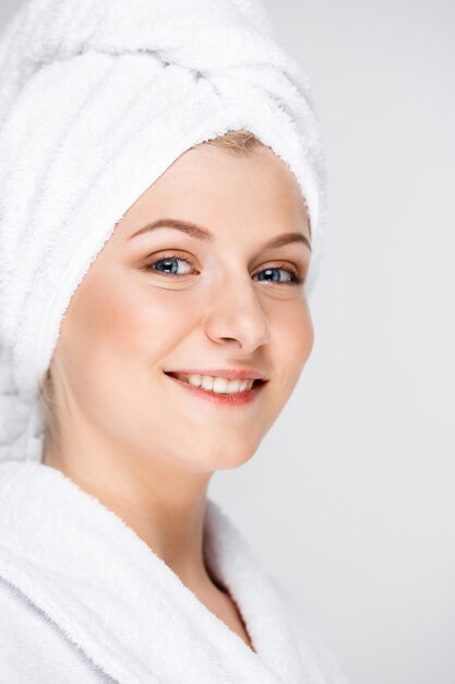 Feliz mujer sonriente aplicar crema facial, concepto de cuidado de la piel