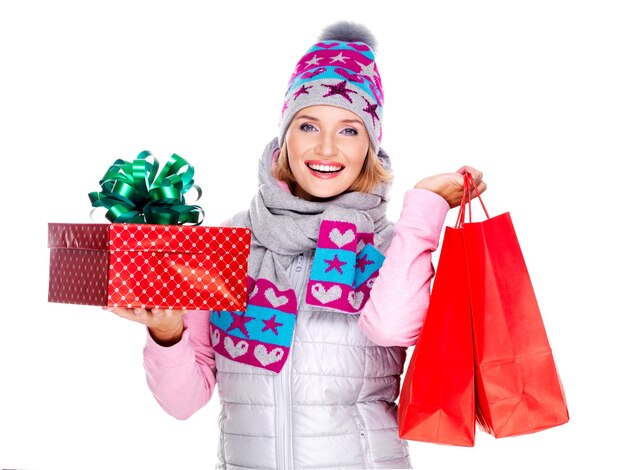 Feliz mujer sonriente con regalos después de ir de compras aislado en blanco