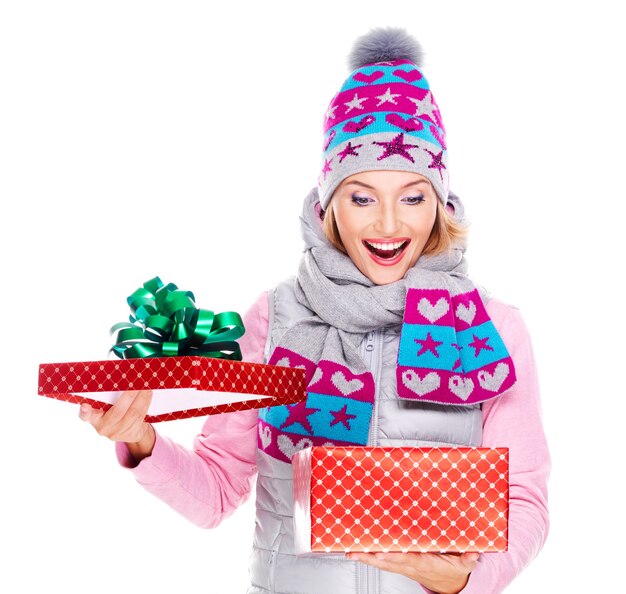 Feliz mujer sorprendida con un regalo de Navidad en una ropa de abrigo de invierno aislado en blanco