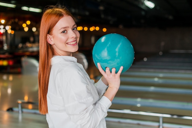 Feliz mujer sosteniendo la bola de boliche