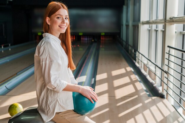 Feliz mujer sosteniendo la bola de boliche