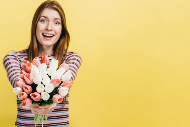 Feliz mujer sosteniendo un ramo de tulipanes con espacio de copia