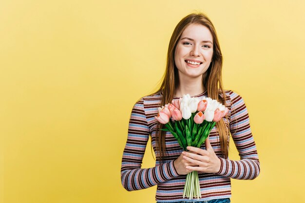 Feliz mujer sosteniendo un ramo de tulipanes