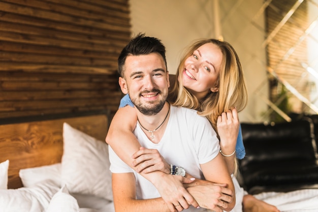 Feliz mujer sosteniendo a su novio en casa