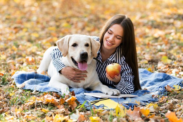 Feliz mujer sosteniendo a su perro en el parque