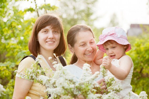 Feliz las mujeres y el niño en el jardín de verano