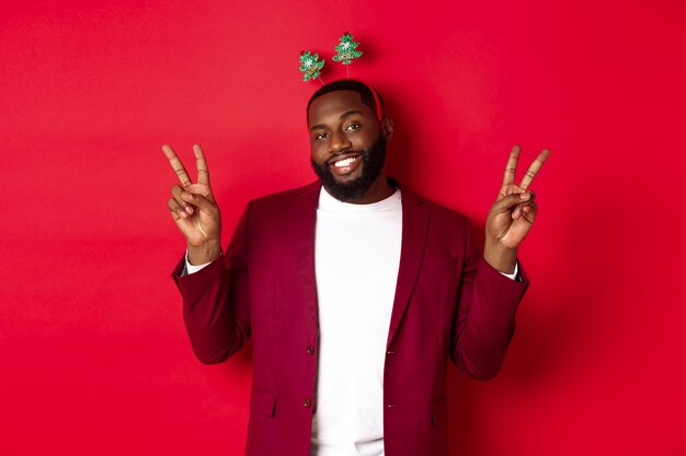 Feliz Navidad. Alegre chico barbudo afroamericano en diadema de fiesta