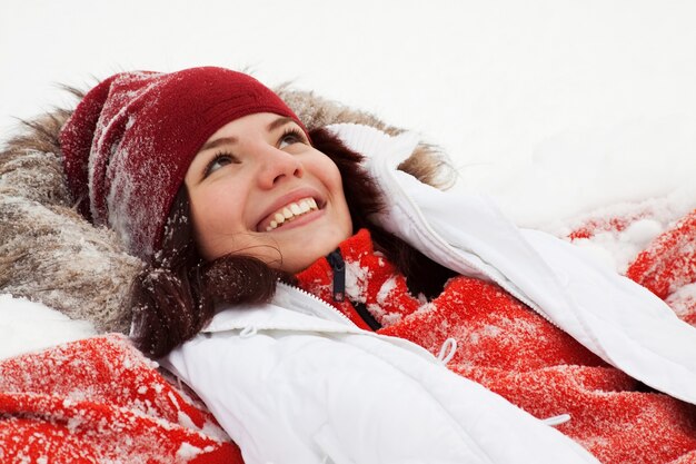 Feliz niña acostada en la nieve