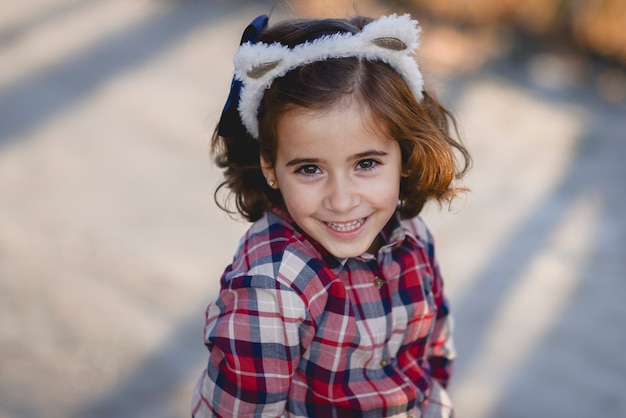 Feliz niña adorable sonriendo al aire libre.