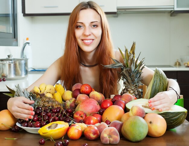 Feliz niña de pelo largo con frutas