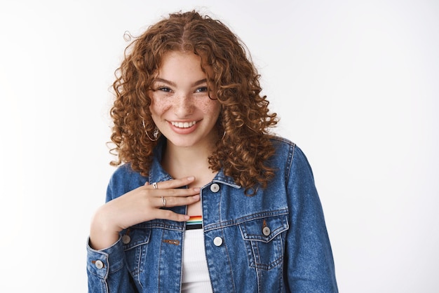 Feliz niña sonriente mantenga la mano sobre su pecho agradecido