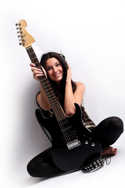 Feliz niña sonriente tocando la guitarra