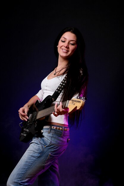 Feliz niña sonriente tocando la guitarra