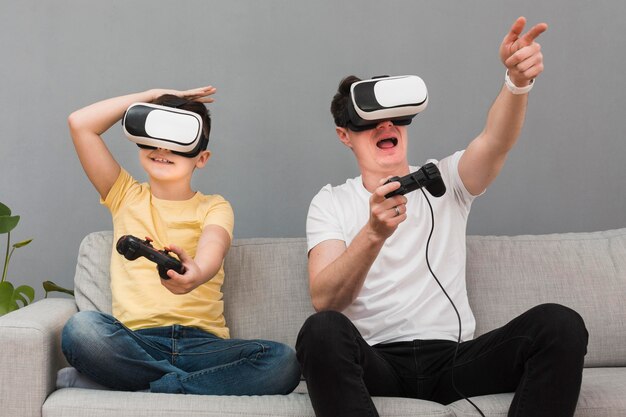 Feliz niño y hombre jugando videojuegos con casco de realidad virtual