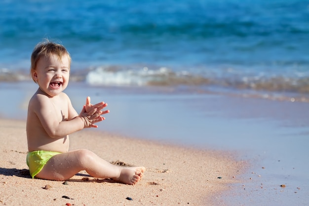 Feliz niño en la playa de arena