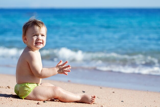 Feliz niño en la playa de arena