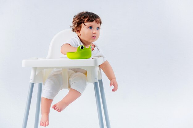 Feliz niño sentado en la silla del bebé