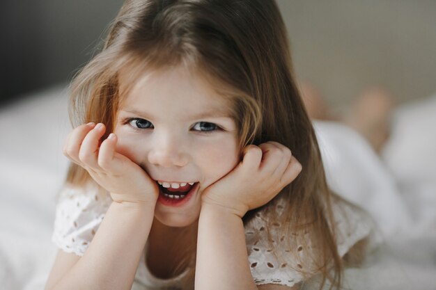 Feliz niño sonriente acostado en la cama