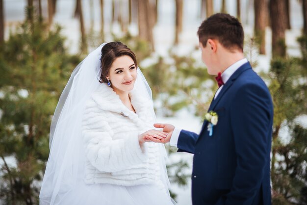 Feliz novia y el novio en el día de invierno en su boda