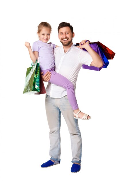 Feliz padre e hija con bolsas de compras de pie