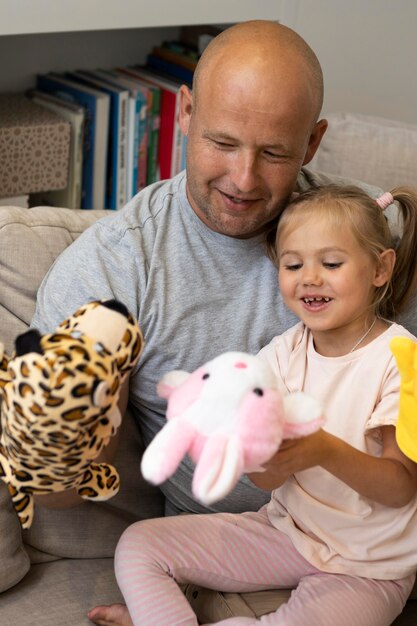 Feliz padre e hija jugando con títeres