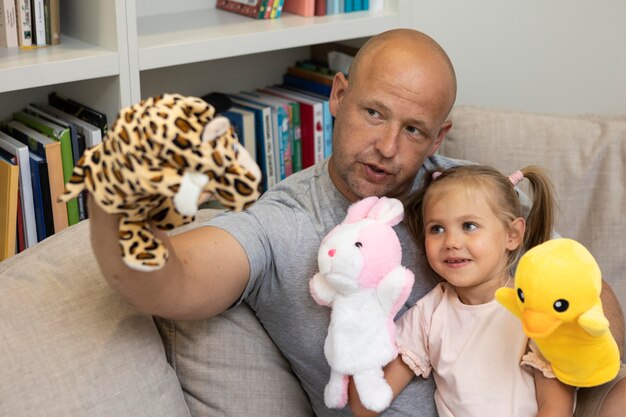 Feliz padre e hija jugando con títeres