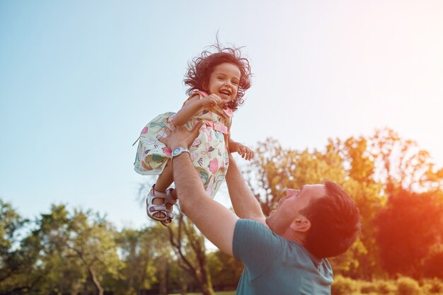 Feliz padre e hija riendo juntos al aire libre