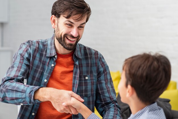 Feliz padre e hijo estrechándole la mano