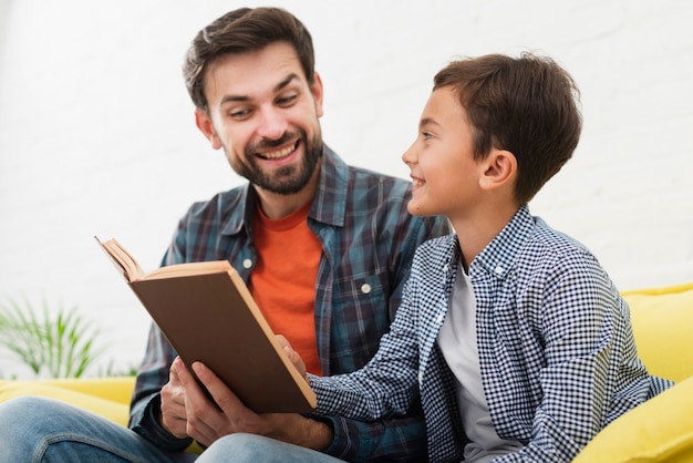 Foto gratuita feliz padre e hijo leyendo